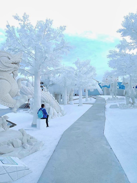 Pathway through ice sculptures at Frost Magical Ice of Siam, featuring mythical creatures.