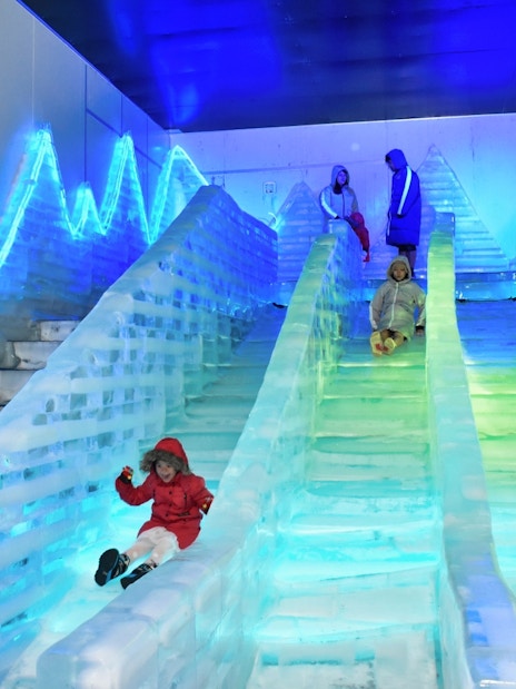 Children sliding down ice slides at Frost Magical Ice of Siam.