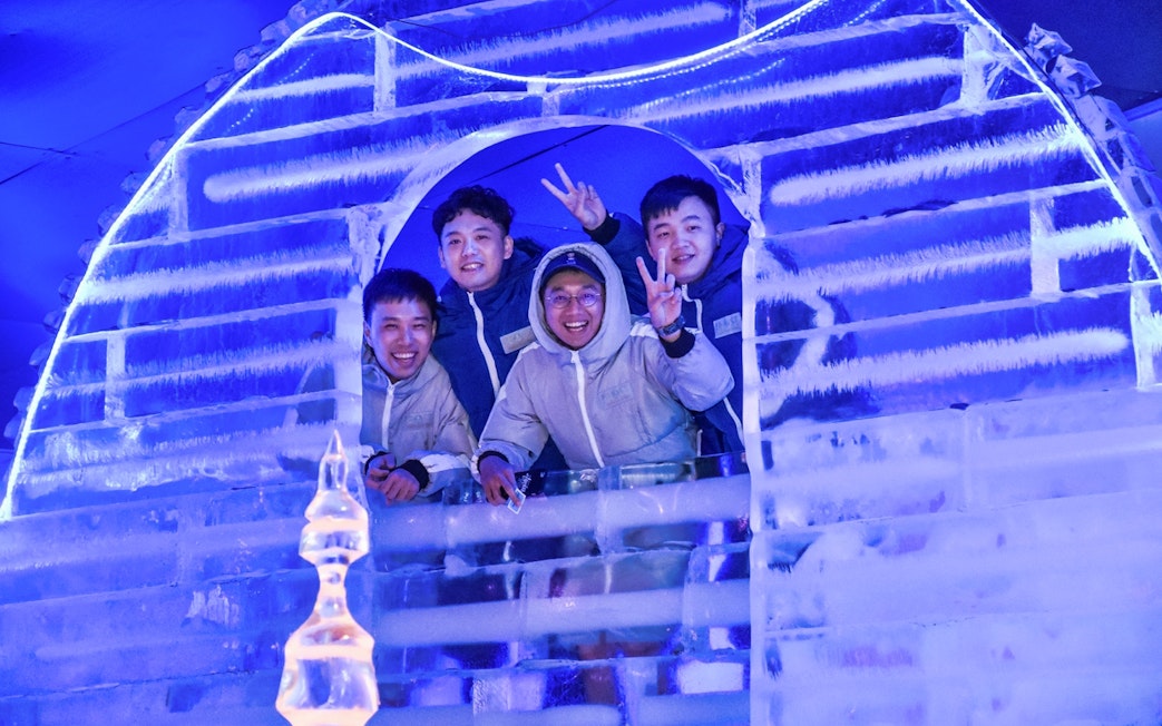 Group enjoying ice sculpture at Frost Magical Ice of Siam, Thailand.