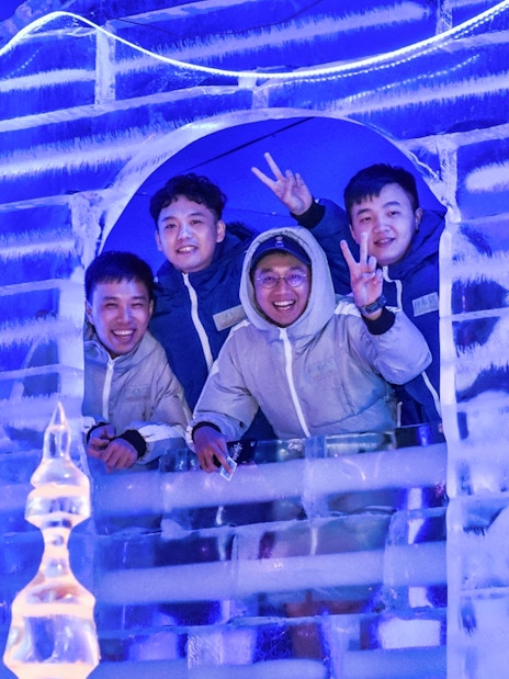 Group enjoying ice sculpture at Frost Magical Ice of Siam, Thailand.