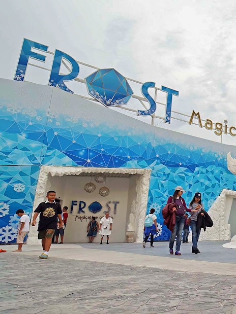 Visitors exploring Frost Magical Ice of Siam with large ice sculptures in Pattaya, Thailand.
