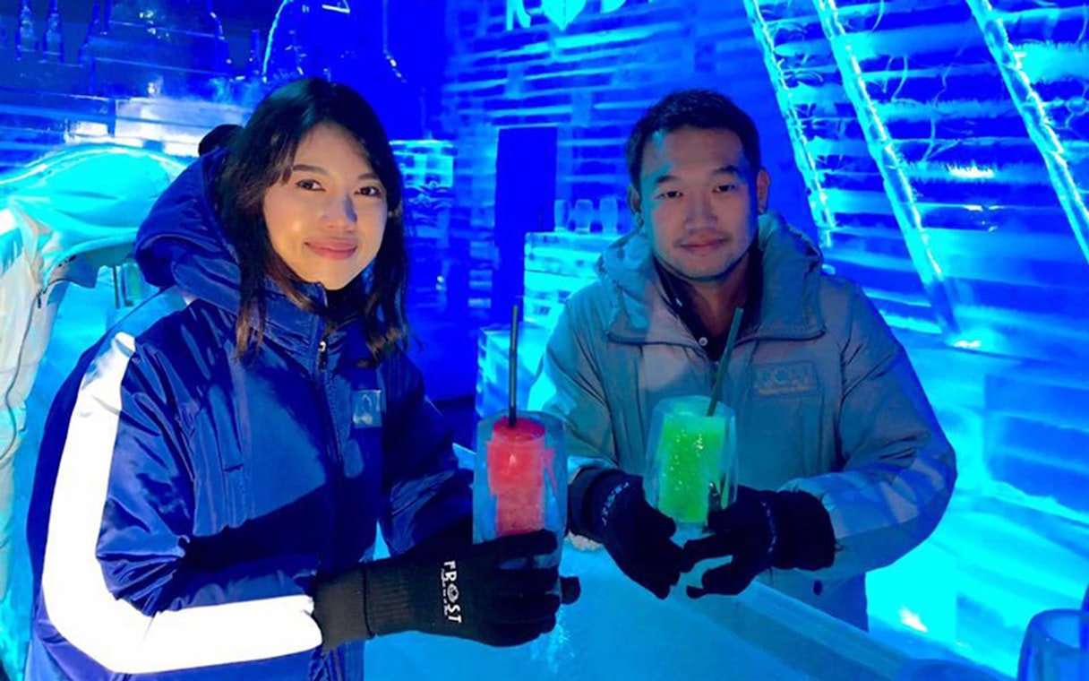 Visitors enjoying drinks at Frost Magical Ice of Siam, surrounded by ice sculptures.