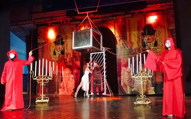 Illusion performance at Tuxedo Illusion Hall Pattaya with performers in red robes and a suspended box.