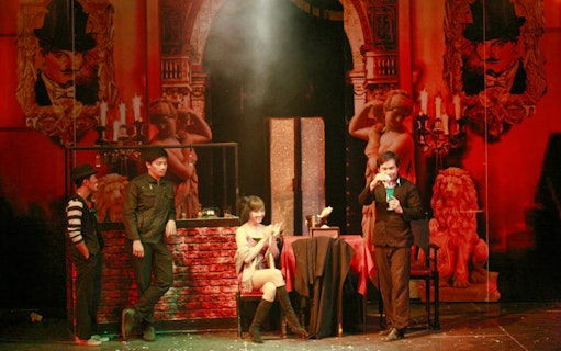 Performers on stage at Tuxedo Illusion Hall in Pattaya, with a magician and theatrical backdrop.