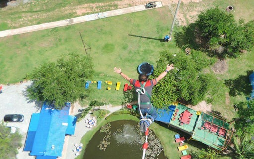 Person bungy jumping over a pond in Pattaya, Thailand.