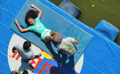 Participant preparing for bungy jump on a platform with instructors nearby.
