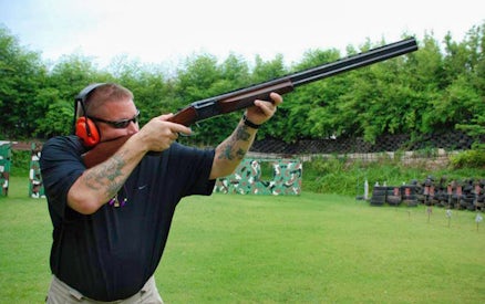 Man aiming shotgun at Pattaya Shooting Park, Thailand.