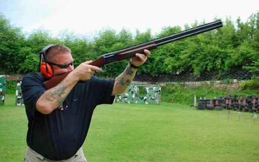 Man aiming shotgun at Pattaya Shooting Park, Thailand.