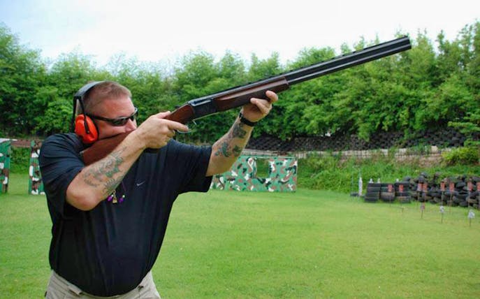 Man aiming shotgun at Pattaya Shooting Park, Thailand.
