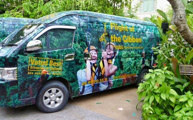 Flight Of The Gibbon Chonburi tour van with zipline graphics in lush greenery.