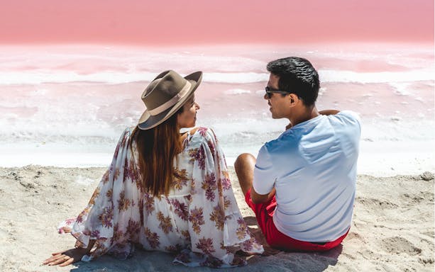 Couple sitting by the pink waters of Las Coloradas during Rio Lagartos tour.