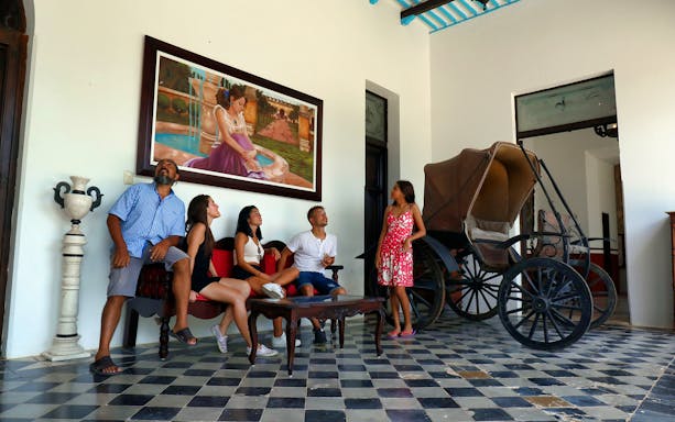 Group of people in a historic room with a carriage, Las Coloradas & Rio Lagartos tour.