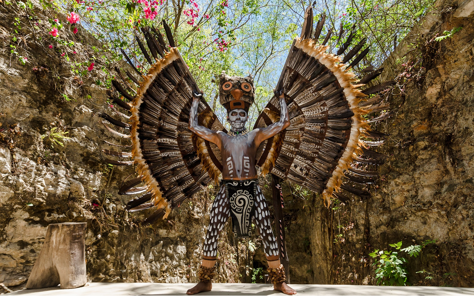 Traditional Mayan performer with feathered costume at Chichén Itzá tour.