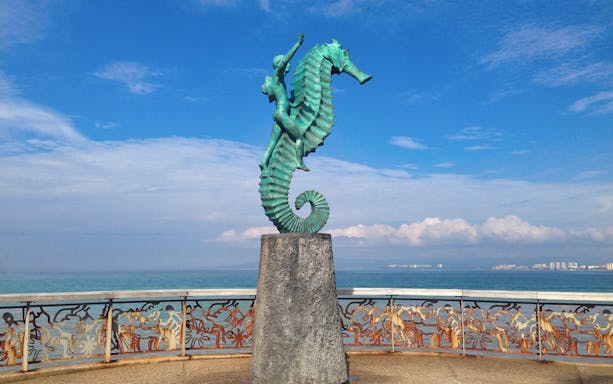 Seahorse sculpture on Puerto Vallarta boardwalk with ocean view.