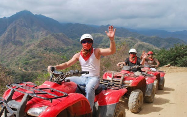 ATV riders on a dirt trail in Puerto Vallarta with mountain views.