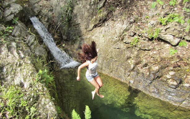 Person jumping into a natural pool during Puerto Vallarta ATV tour.