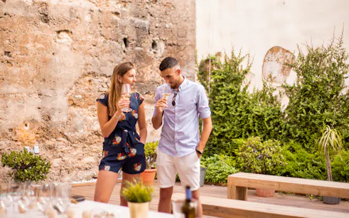 Couple enjoying wine in Valencia's Old Town 11th-century monument courtyard.
