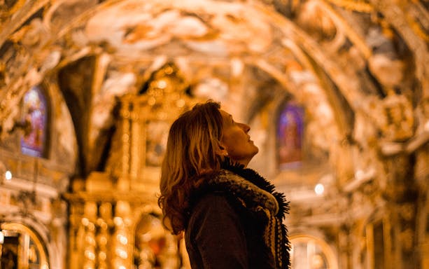 Visitor admiring ornate ceiling in Valencia's 11th-century monument during Old Town tour.