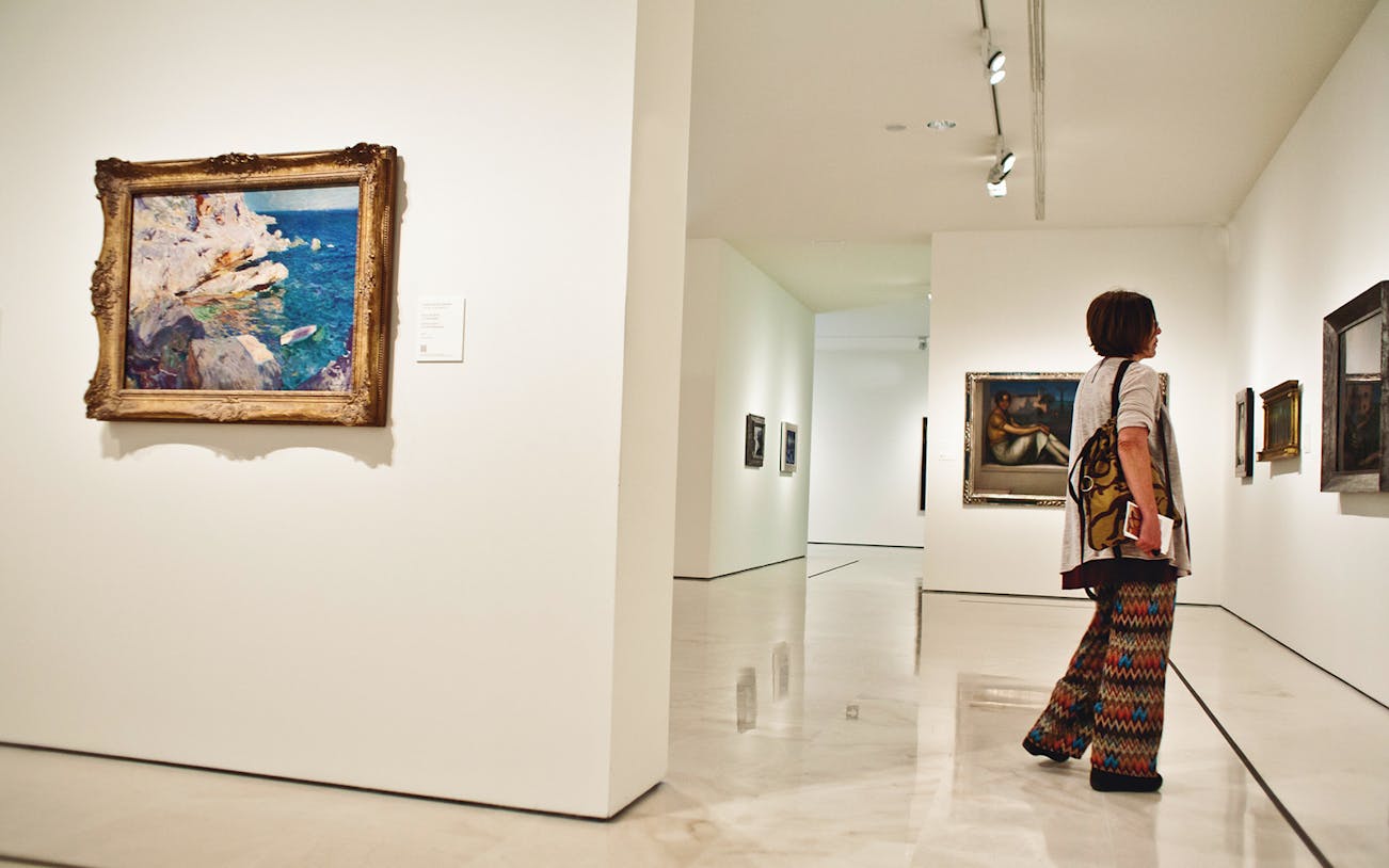 Visitor admiring paintings at Carmen Thyssen Museum, Málaga.