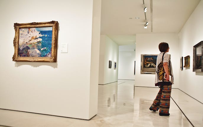 Visitor admiring paintings at Carmen Thyssen Museum, Málaga.