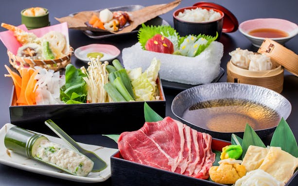 Traditional Japanese meal with sashimi, tempura, and hot pot ingredients on Kyoto Nara tour.