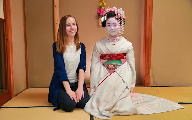 Person with Maiko in traditional attire during Gion Kyoto tour.