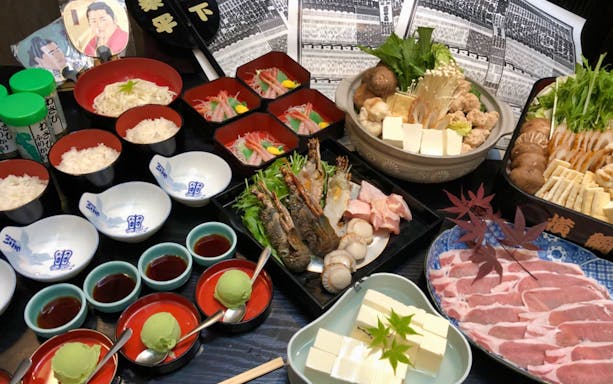 Traditional Japanese meal with sushi, sashimi, and hot pot ingredients in Kyoto tour.