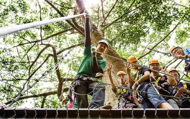 Participants preparing for Jungle Flight Zipline Adventure in a lush forest setting.