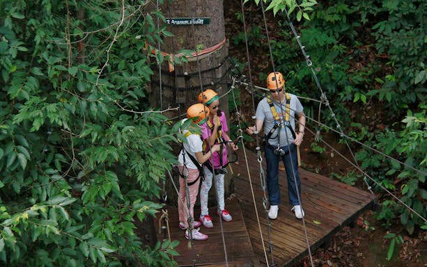 Participants preparing for Jungle Flight Zipline Adventure in lush forest setting.