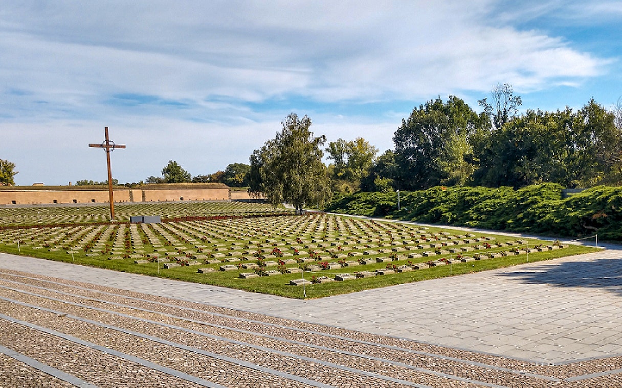 Terezin Concentration Camp cemetery with cross and rows of graves, Czech Republic.