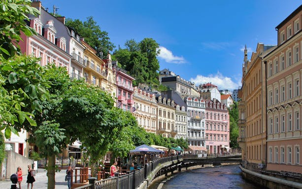 Colorful historic buildings along the river in Karlovy Vary, Czech Republic.