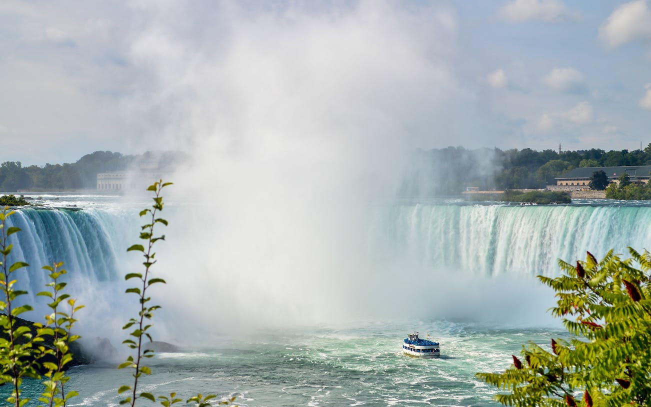 Boat approaching Niagara Falls with mist rising, part of the Cave of the Winds tour.
