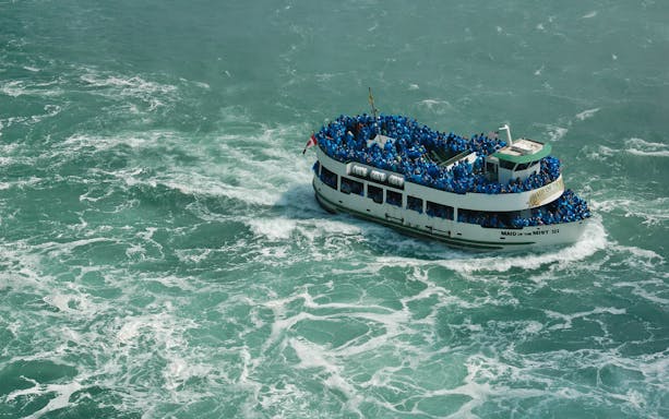 Tour boat Maid of the Mist near Niagara Falls with passengers in blue ponchos.