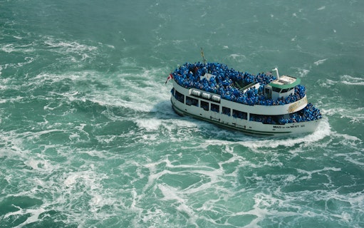 Maid of the Mist boat with tourists in blue ponchos at Niagara Falls.