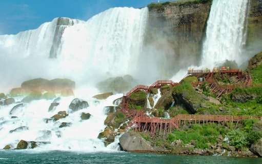 Niagara Falls with wooden walkways and tourists on a guided tour.
