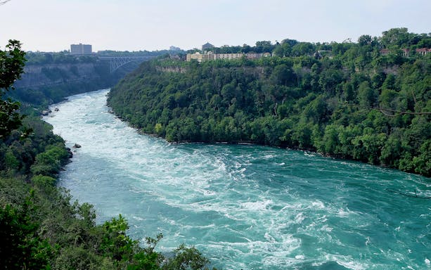 Niagara River view with lush greenery, part of the Niagara Falls Walking Tour.