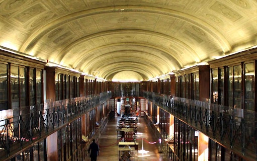 Interior of the Royal Palace of Turin library with arched ceiling and bookshelves.