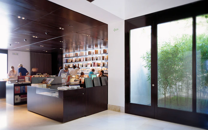 Visitors browsing books at Picasso Museum gift shop in Malaga, Spain.