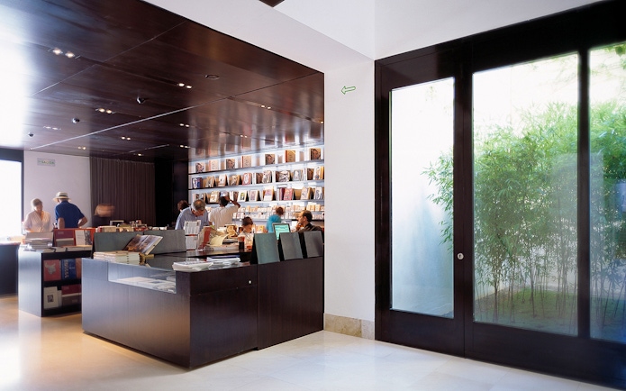 Visitors browsing books at Picasso Museum gift shop in Malaga, Spain.