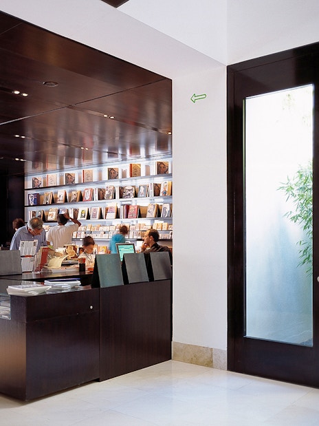 Visitors browsing books at Picasso Museum gift shop in Malaga, Spain.