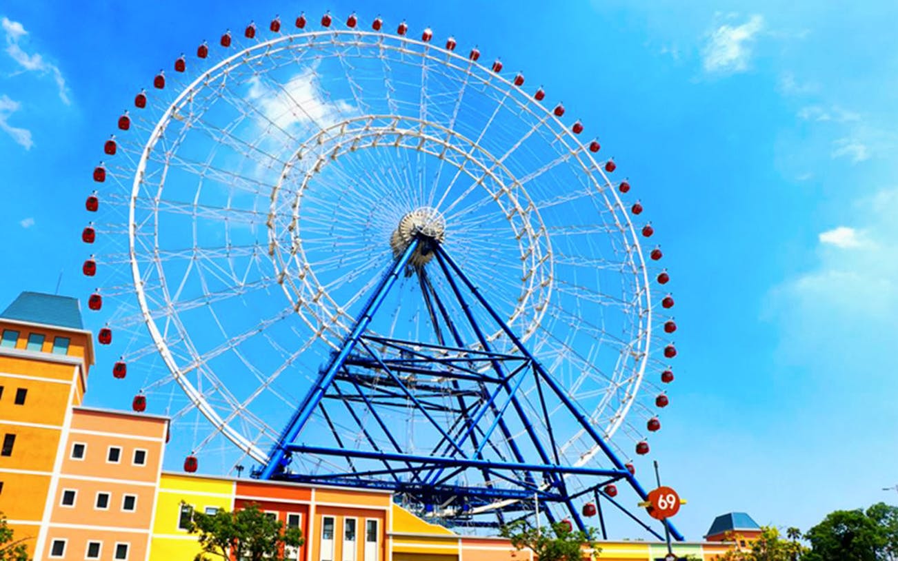Ferris wheel at Lihpao Land Theme Park in Taichung against a blue sky.