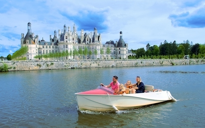 Family boating near Chambord Castle, France.