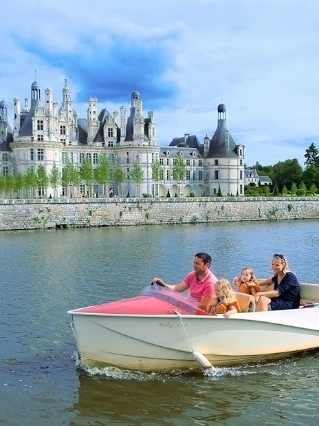 Family boating near Chambord Castle, France.