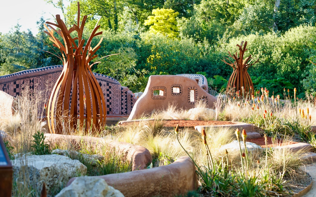 Loire Valley garden with unique sculptures and patterned walls surrounded by greenery.