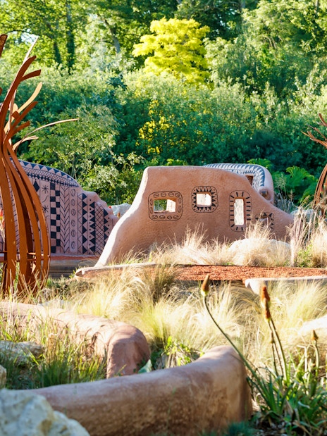Loire Valley garden with unique sculptures and patterned walls surrounded by greenery.