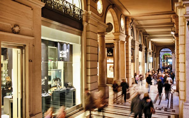 Shopping arcade in Torino, Italy, with Montblanc store and people walking.