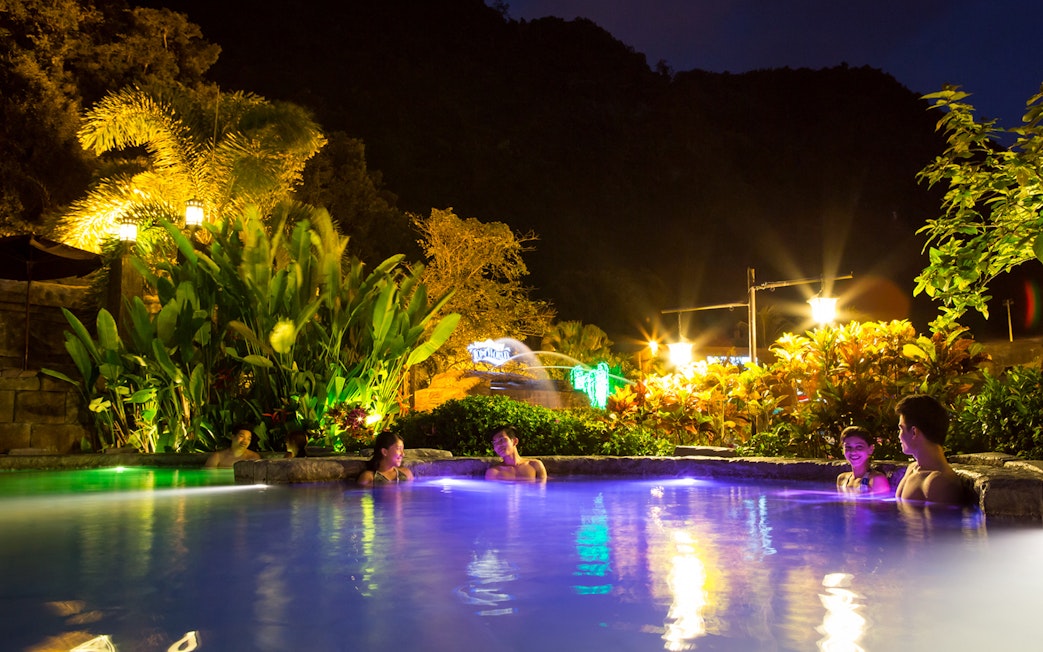 Infinity pool at night with people relaxing, Sunway Lost World of Tambun, Malaysia.