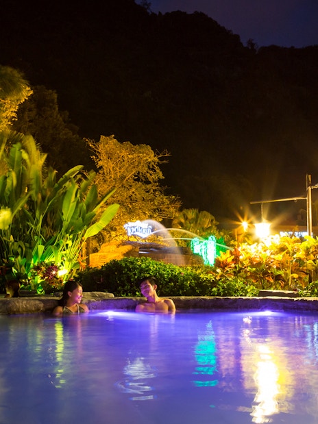 Infinity pool at night with people relaxing, Sunway Lost World of Tambun, Malaysia.