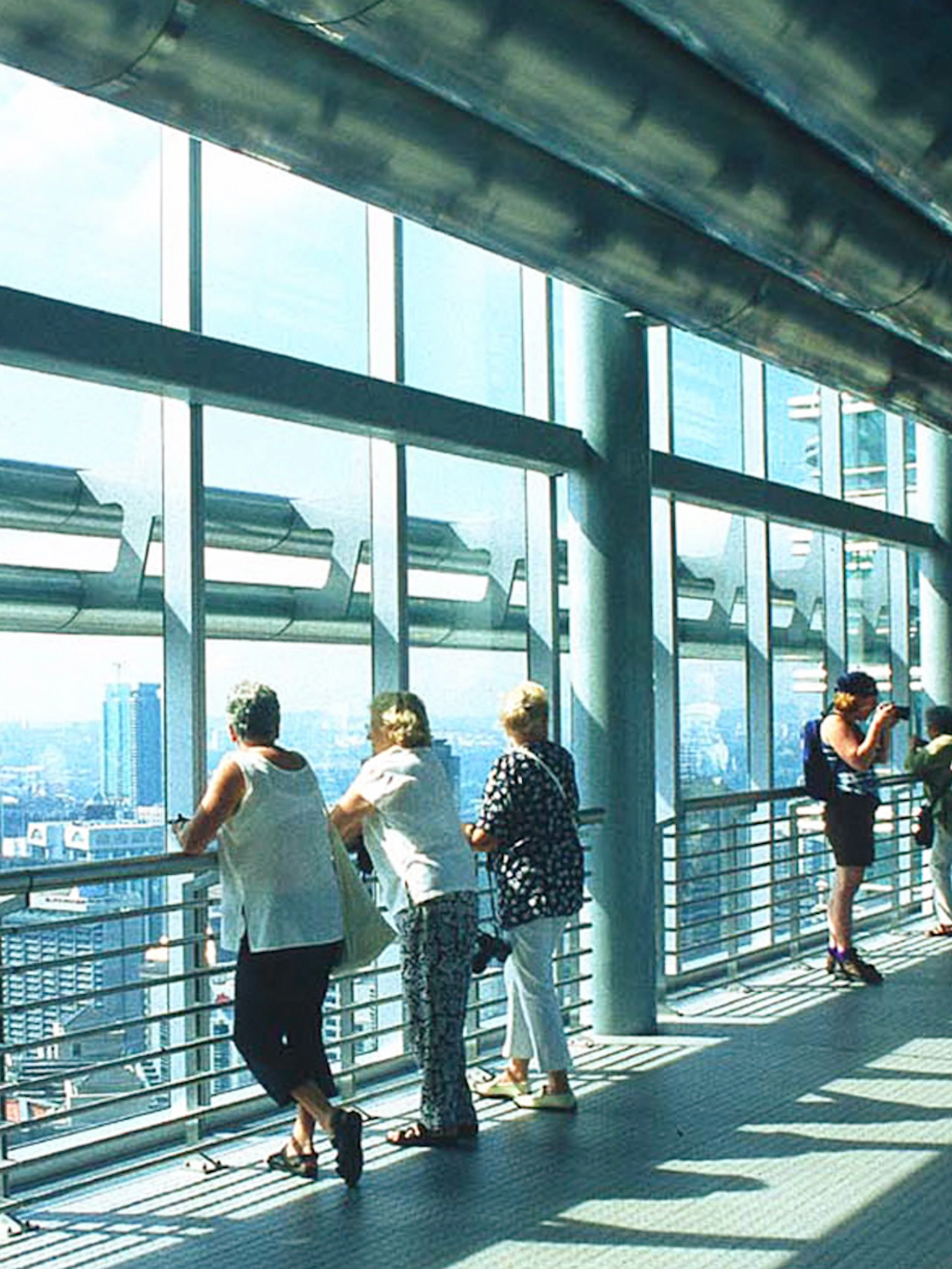 Visitors on the Petronas Twin Towers skybridge, Kuala Lumpur, enjoying city views.