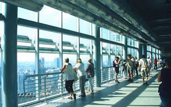 Visitors on the Petronas Twin Towers skybridge, Kuala Lumpur, enjoying city views.